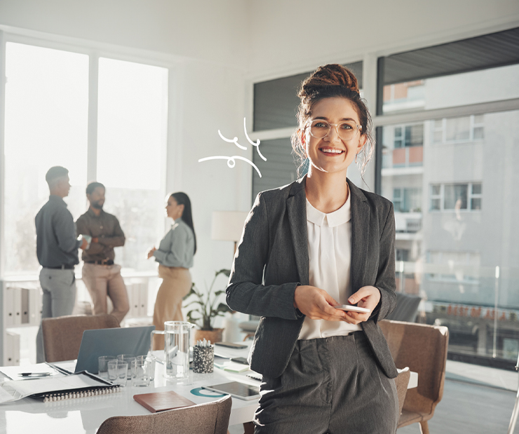 junge Frau mit Brille und Business-Outfit steht im Konferenzraum