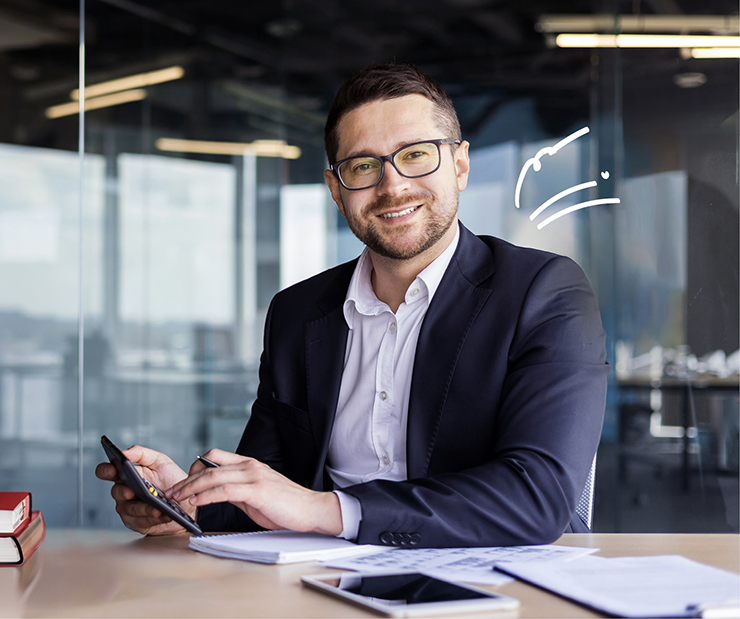 junger Mann mit Brille und Anzug hält einen Taschenrechner in der Hand